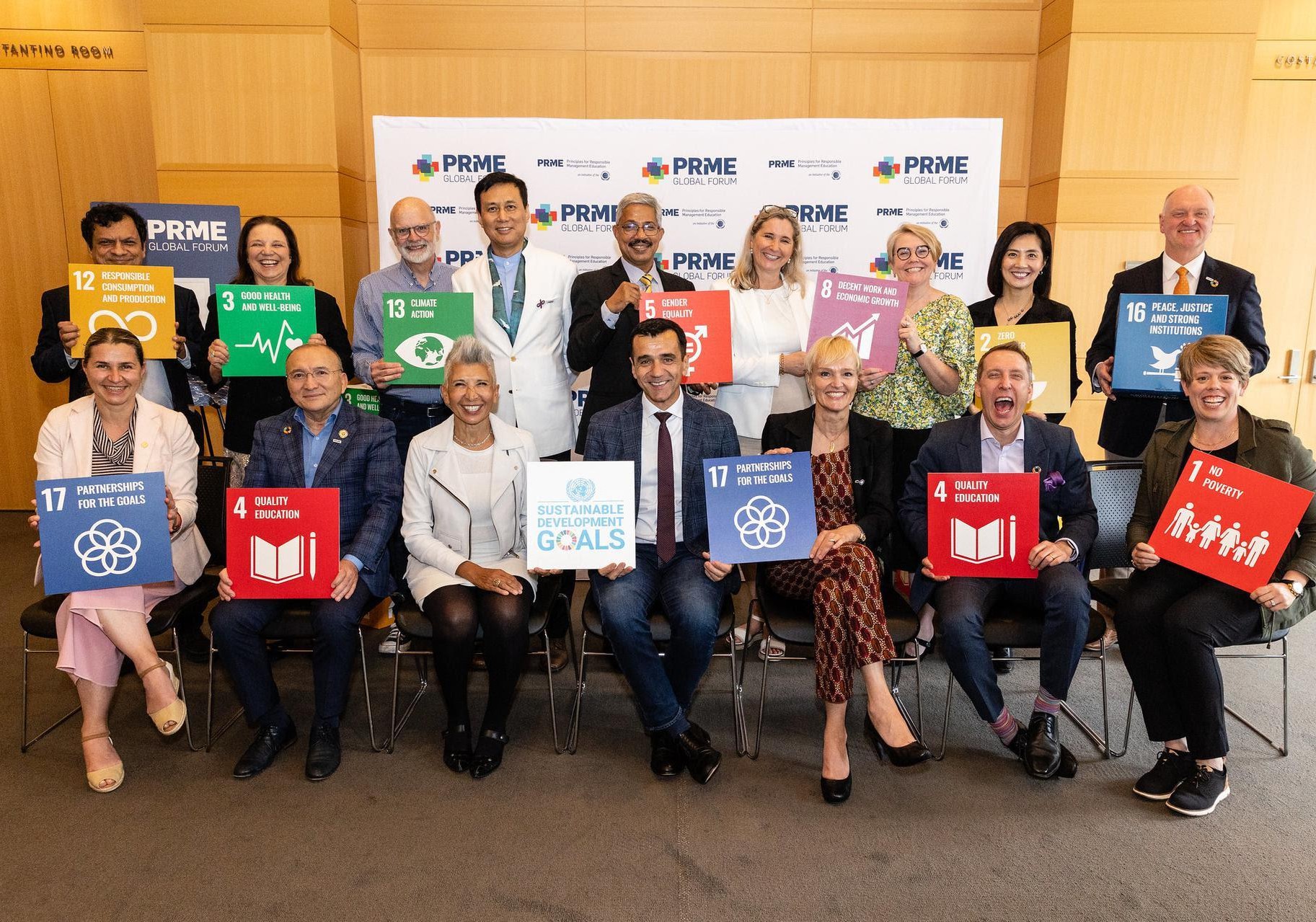 Participantes do PRME Global Forum segurando cartazes dos Objetivos de Desenvolvimento Sustentável